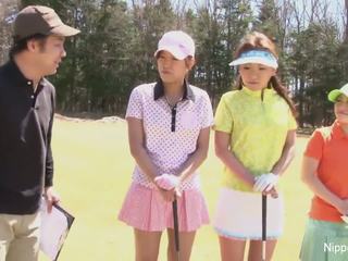 Monada asiática niñas jugar un juego de desvistiéndose golf
